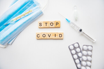 Stop coronavirus inscription. Preparation for vaccination against covid-19. Syringe, vaccine, pills, medical mask.