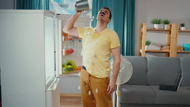 problem of hot weather, a funny man with a mustache experiencing sweating overheating is cooled by bucket of icefrom the refrigerator