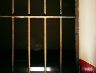 Prison door bars in prison cell closed on dark background