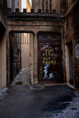 Fototapeta na wymiar Mediterranean street in the town with graffiti on a metal door 