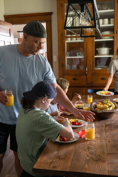Marine veteran at home with family eating and fixing breakfast.