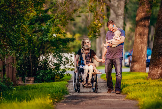 A family out walking in the evening and the mother is a paraplegic in a wheelchair; Edmonton, Alberta, Canada