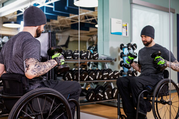 A paraplegic man working out using free weights in front of a mirror at recreational centre: Sherwood Park, Alberta, Canada