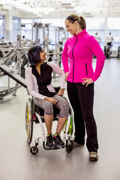 A paraplegic woman talking with her personal trainer and her trainer after a successful workout in a recreational facility: Sherwood Park, Alberta, Canada