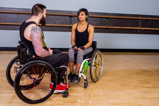 Two paraplegic friends talking together and encouraging each other after working out at a fitness facility: Sherwood Park, Alberta, Canada