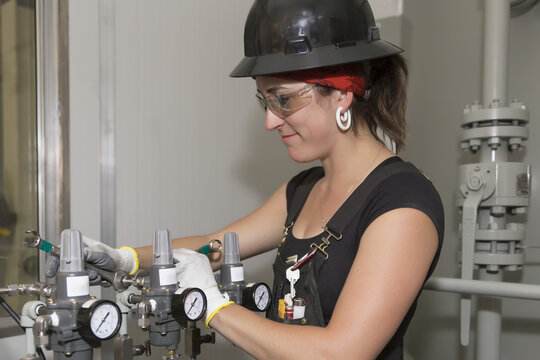 Female trades worker installing a fuel gas regulator; Innisfail, Alberta, Canada