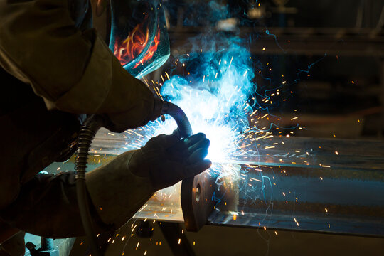 A journeyman welder installing a lift lug using a MIG welder in a metal fabrication plant; Innisfail, Alberta, Canada