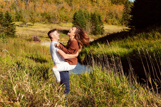 Husband and wife spending quality time together outdoors near a stream in a city park; Edmonton, Alberta, Canada