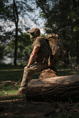 A soldier in specialized ammunition. Special tactical backpack. Backpack for fishing and hunting