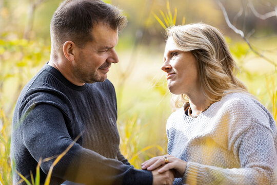 A mature married couple spending quality time together in a city park during the fall season; St. Albert, Alberta, Canada