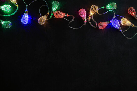 Top view of garland with colorful lights, place for text