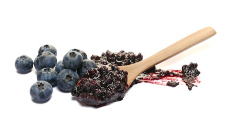 Blueberry jam, marmalade in wooden spoon and fresh berries isolated on white, side view
