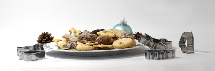 homemade Christmas cookies on a plate with cookie cutters