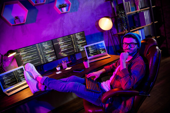 Photo of thoughtful minded coder dressed hat eyewear creating safety system indoors workplace workstation loft
