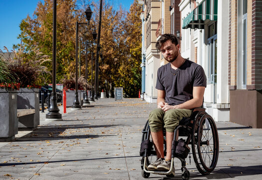 Outdoor portrait of a young paraplegic man in his wheelchair on a city walkway on a beautiful fall day; Edmonton, Alberta, Canada