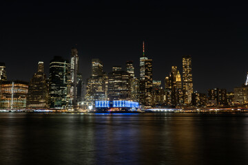 Fototapeta na wymiar New York - Manhattan at night. Skyscrapers of a large metropolis. Night city at long exposure. Towers in the big city.