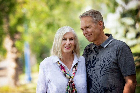 Outdoor portrait of a mature couple in a park, the husband looking at the wife; Edmonton, Alberta, Canada