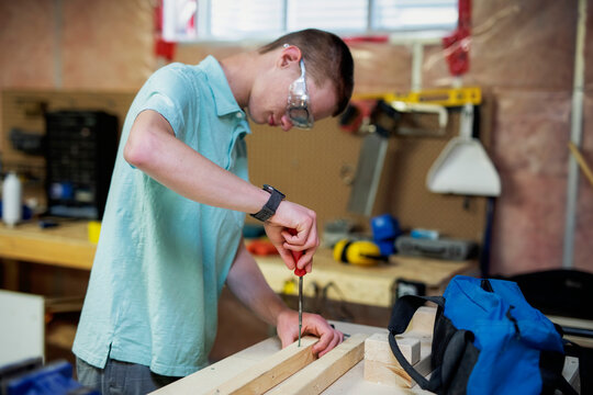 Young man doing woodworking in his basement; Edmonton, Alberta, Canada