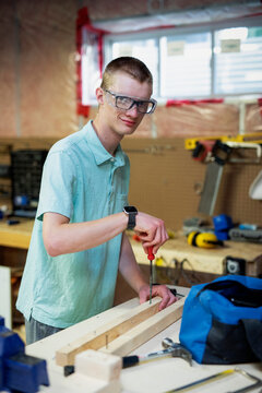 Young man doing woodworking in his basement; Edmonton, Alberta, Canada