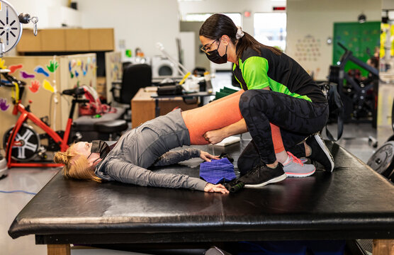 A paraplegic woman doing assisted hip thrusters with her trainer: Edmonton, Alberta, Canada