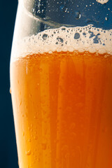 foam and bubbles in a beer glass close-ups on a blue background.