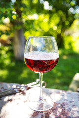 A glass of dark beer in a glass, standing on a table, outdoor recreation. Summer picnic, beautiful sunshine.