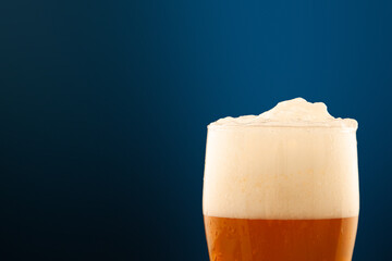 foam and bubbles in a beer glass close-ups on a blue background.
