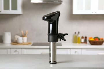 Thermal immersion circulator on white table in kitchen. Sous vide cooking