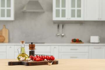 Fresh cherry tomatoes, oil, garlic and peppercorns on wooden table in kitchen. Space for text