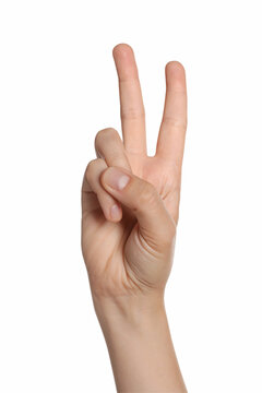 Woman showing peace gesture on white background, closeup of hand