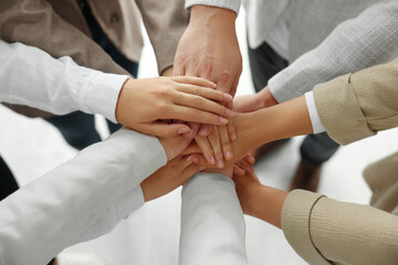 Group of people holding hands together indoors, above view. Unity concept