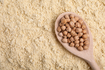 Spoon with seeds on chickpea flour, top view. Space for text