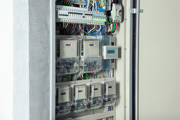 Open electrical fuse box with many electric meters
