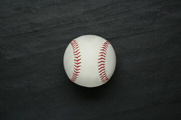 Baseball ball on black slate background, top view. Sports game