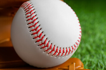 Baseball ball on green grass, closeup. Sports game