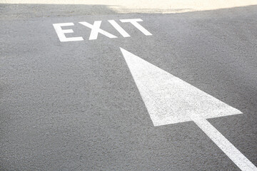 White painted arrow and exit marking on road outdoors