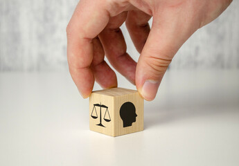 Business ethics concept. Hand flip ethics inside a head symbols in wooden cubes on dark background...
