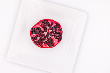 Food shots of a red pomegranate half with seeds from bird's eye view