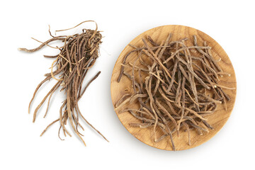 Dried Valerian root in wooden bowl isolated on white background. Valeriana officinalis with full depth of field. Top view. Flat lay - obrazy, fototapety, plakaty