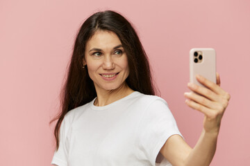 portrait of a beautiful emotional woman with a fashionable phone in her hands takes a selfie with her hand outstretched forward