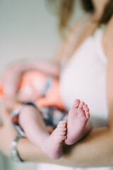 baby's little feet with mother in the background