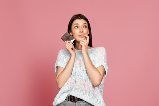 young woman in sweater holding chocolate bar