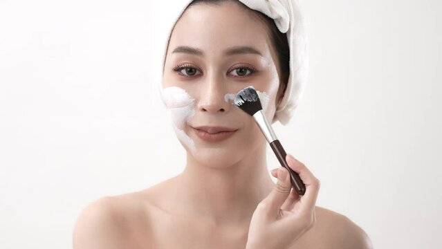 Spa concept of 4k Resolution. Asian woman applying facial cream in bedroom. Mud Mask. green tea extract.