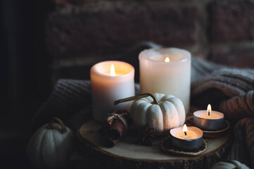 Autumn home composition with aromatic candle, dry citrus, cinnamon, anise. Aromatherapy on a grey fall morning, atmosphere of cosiness and relax. Wooden background close up copy space