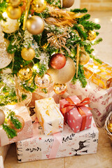 boxes with gifts on the Christmas tree with classic decorations.