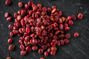 dry aromatic sumac spice on a black stone background