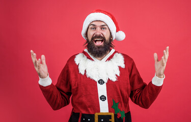 Fototapeta na wymiar amazed brutal bearded guy in santa claus costume on christmas eve, new year surprise