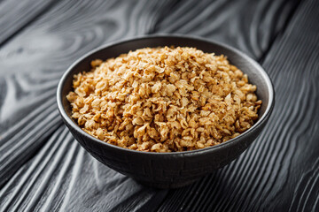 fresh raw buckwheat flakes on a black wooden background
