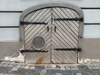 Small old wooden door withn iron hinges. Building in Old town of Riga, Latvia.