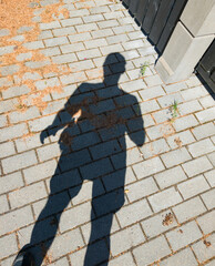 Shadow of man on pavement. Sunny day.